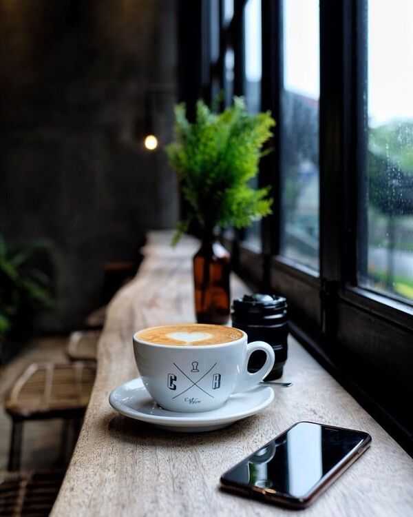 Rami rytinė scena: puodelis ir šviesa prie lango